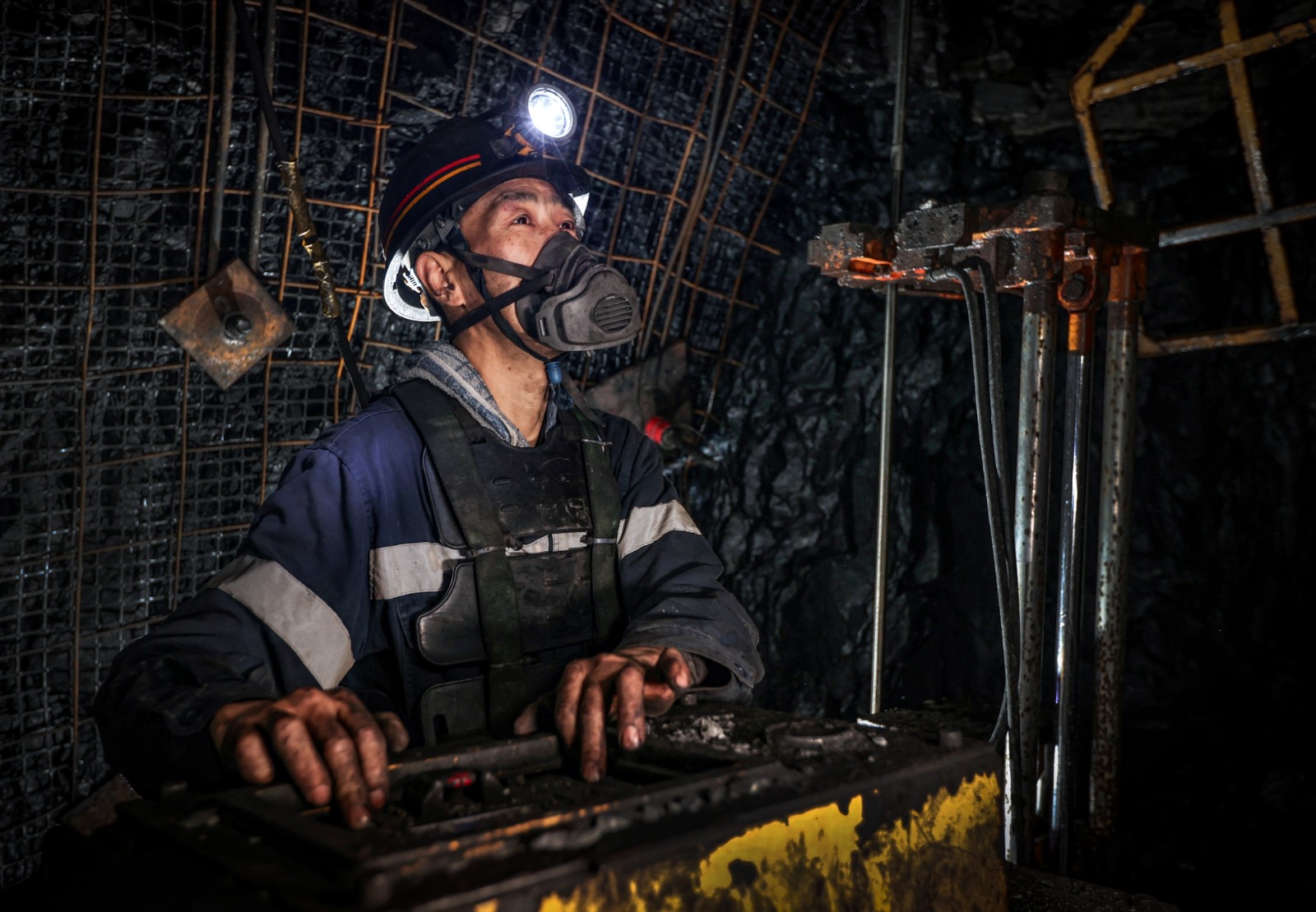 班組職工操作錨桿鉆機對巷道頂板進行支護作業。